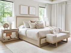 a large white bed sitting in a bedroom next to a window