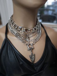 This handmade chunky stainless steel chain layered necklace set is a stunning piece of jewelry that is perfect for those who love bold and edgy accessories. This is two necklaces, the big chunky choker that is adjustable with a built-in extender, and the 4-strand drop festoon design necklace (also adjustable). Adding depth and dimension to the piece is a u lock and arrowhead pendant. Very punk, grunge aesthetic! All the chains are made of sturdy stainless steel, ensuring durability and longevity, and making it completely hypoallergenic, waterproof, and non tarnish. It will look exactly like this forever!  This necklace set is an excellent handmade gift for someone special. It is a perfect choice for those who love alternative and goth styles, as well as anyone who wants to make a statement Necklace Layering Grunge, Shackles Chains Aesthetic, Aesthetic Chains Necklace, Punk Grunge Aesthetic, Big Chain Necklace, Goth Styles, Arrowheads Jewelry, Chains Aesthetic, Edgy Necklace