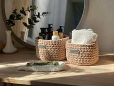two baskets with towels and soaps sit on a table in front of a mirror