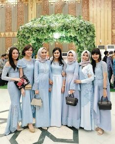 the bridesmaids are dressed in blue dresses and posing for a photo at an event