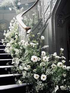 white flowers are growing on the bottom of some stairs