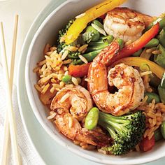 shrimp, broccoli, peppers and rice in a bowl with chopsticks