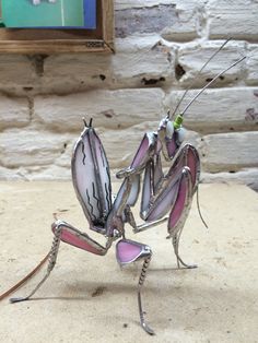 a metal insect sitting on top of a wooden table