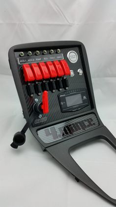 an electronic device with four red knobs on the front and two black buttons on the back