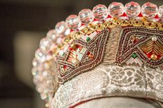 a close up view of a headpiece with beads and jewels on it's face