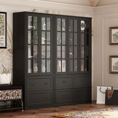 a black china cabinet with glass doors and drawers in a living room next to a rug on the floor