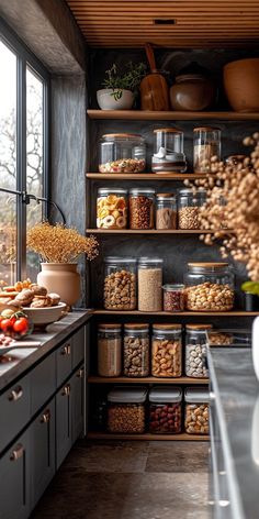 a kitchen filled with lots of food on top of shelves next to an open window