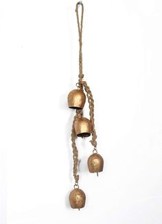 three bells hanging from a rope on a white wall