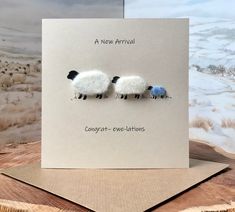 two sheep standing next to each other on top of a card