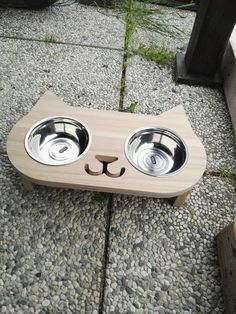 a wooden cat bowl holder with two bowls on it