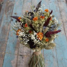 a bouquet of flowers sitting on top of a blue wooden floor next to a wall