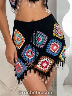 a close up of a person wearing shorts with crocheted designs on the bottom