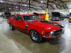 a red car parked in a garage next to other cars