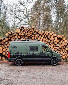 a van parked in front of a pile of logs