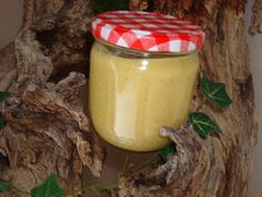 a jar filled with yellow liquid sitting on top of a tree