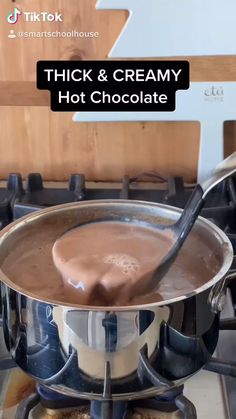a pan filled with hot chocolate sitting on top of a stove
