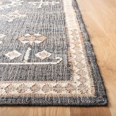 an area rug on the floor with wood floors in the background and a wooden floor