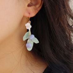 a close up of a person wearing some kind of earring with flowers on it