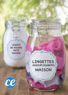 three jars filled with pink and white flowers on top of a wooden table next to each other