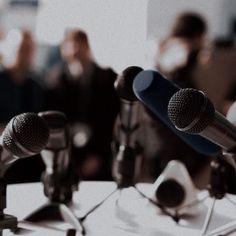 two microphones sitting on top of a table in front of a group of people