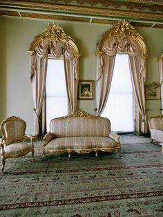 an ornately decorated living room with couches and chairs