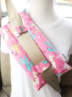the back of a woman's car seat belt with pink and blue cactus print
