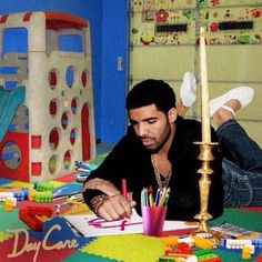 a man laying on the floor in front of a birthday cake with candles and crayons