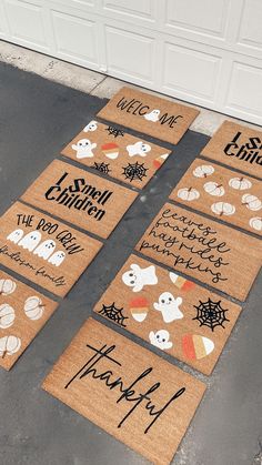 halloween doormats with words and ghostes on them in front of a garage