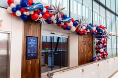 red, white and blue balloons are on display at the entrance to an office building