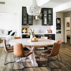 a dining room table with chairs and a chandelier hanging from the ceiling