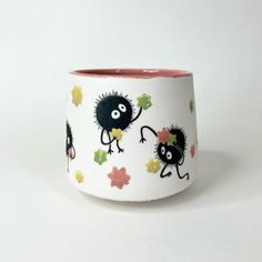 a white cup with black monsters on it