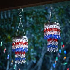 two red, white and blue chandeliers hanging from chains with lights in the background