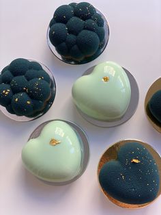 four desserts with blue frosting and gold sprinkles in bowls on a white surface