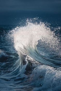 an ocean wave is breaking on the water and it looks to be crashing into shore