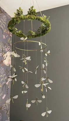 a wind chime hanging from the ceiling next to a wall with flowers on it