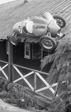 a car is upside down on the roof of a house