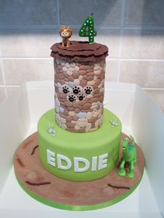 a birthday cake made to look like a tower with animals on top and the words eddie written in green