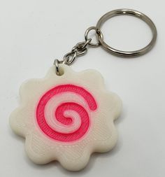 a pink and white keychain with a spiral design on the outside of it