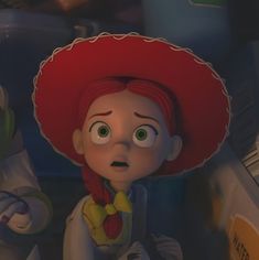 the animated character is wearing a red hat and sitting next to other toy figures in front of him
