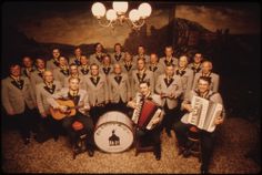 a group of men in suits and ties are posing for a photo with an accordion