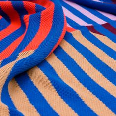 a blue and orange striped blanket laying on top of each other