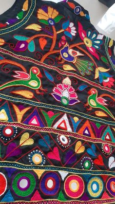 an embroidered vest with colorful designs on it