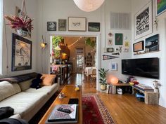 a living room filled with furniture and pictures on the wall