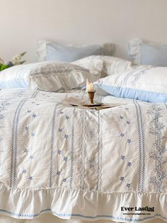 a bed with blue and white linens on it