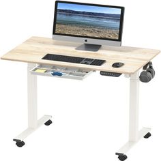 a computer desk with a monitor and keyboard on it's stand, sitting in front of a white background