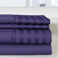 the purple sheets are stacked on top of each other