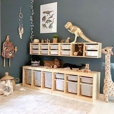 a child's playroom with toys and stuffed giraffes on the wall