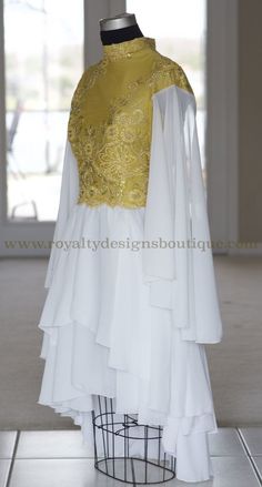 a white and yellow dress on display in a room