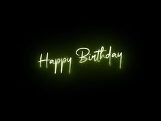 the words happy birthday are lit up in the dark with green light on it's side