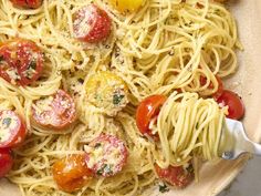 a bowl full of pasta with tomatoes and parmesan cheese